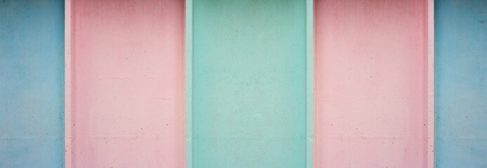 Fototapeta premium Horizontal banner with blue, green and pink stripes. Seamless pattern. Concrete wall. Pastel muted color. Wide line. Bold minimalism. Copyspace. Retro. Multicolored building fence. Minimalism for kids