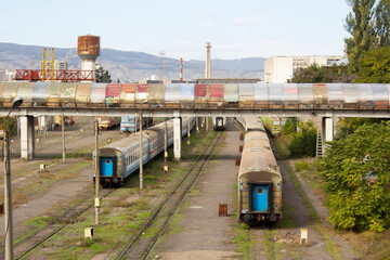 City street photo. Landscape overlooking railway in Georgian city of Tbilisi. Old rusty abandoned train carriage. Water tower. Bridge over road. Sunny summer day. Travel, tourism, adventure. Transport