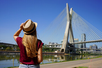 Tourism in Sao Paulo. Back view of traveler girl enjoying sight of Estaiada bridge in Sao Paulo,...