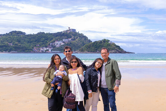 Family of five adults and a baby at the beach and in springtime