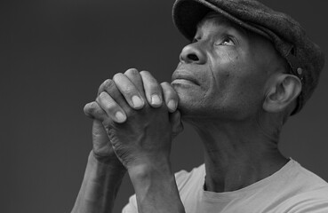 man praying to god with hands together worshiping God Caribbean man praying stock image stock photo	