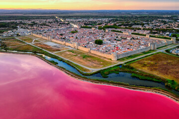 The pink salt lake and the medieval Old town of Aigues-Mortes, Camargue, France - obrazy, fototapety, plakaty