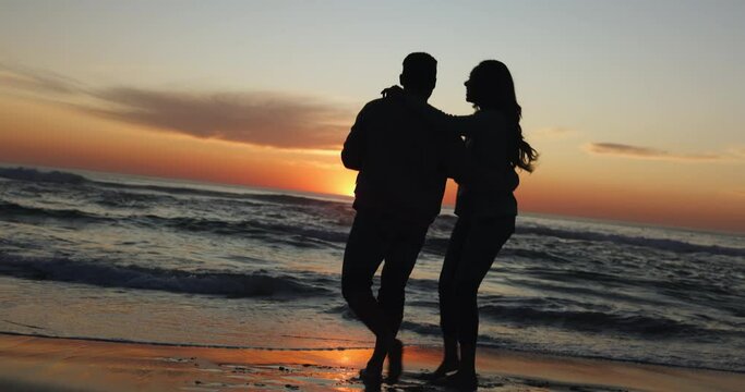Sunset, dancing and couple on a beach for vacation or tropical holiday together for love or care on island. Silhouette, man and woman with happiness on anniversary with travel freedom at ocean
