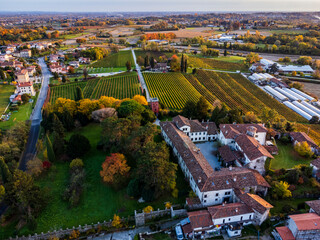 Autumnal magic and emotions on the ancient village. Between vineyards and colorful woods. Friuli. Top view