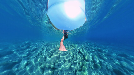 Man snorkeling with 360 degree underwater camera in the beautiful, crystal clear sea at Zuljana beach, Croatia