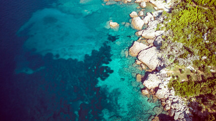 Aerial view of amazing shoreline at the Mokalo beach near town of Orebic on Peljesac peninsula, Croatia, with large stone rocks partially submerged in turquise sea water