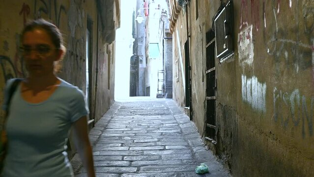 Genoa, Liguria, Italy. June 3, 2023. Engaging pov footage walking through the alleys of the historic center, we meet a middle-aged woman. Explore and discover Genoa.