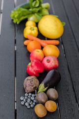Obraz na płótnie Canvas variety of fruits and vegetables on wooden black table