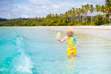 Child on tropical beach. Sea vacation with kids.