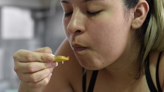 close up of latin woman eating the food she prepared, eating the platano macho crushed with guisado or patacones, typical food.