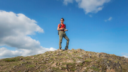 Obraz premium Adventurer holding camera on the peak of Malvern Hills, Worcestershire, United Kingdom.