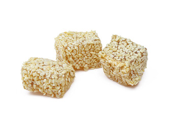 Turkish jelly lokum cubes covered in sesame seeds isolated on white background