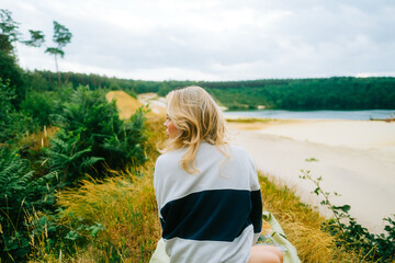 Portrait of attractive caucasian woman making picnic near forest lake, calm and enjoying nature