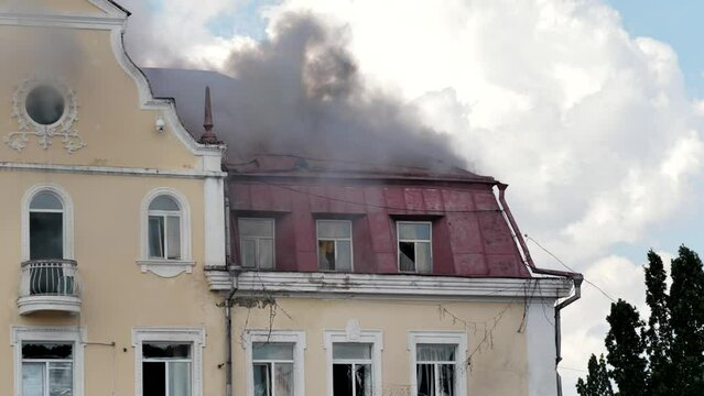 Fire in a historic building. Black smoke over the burning roof of an old house.