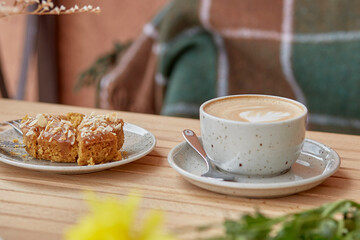 Sliced doughnut and cappuccino at the terrace. Aesthetic breakfast in cold autumn weather concept