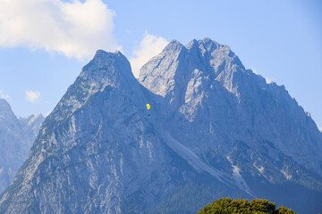 The Zugspitz massif in the Wetterstein mountains with paragliders seen from Garmisch-Partenkirchen...