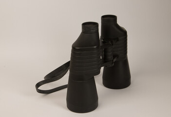 A pair of old black binoculars on a white background