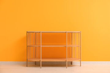 Wooden shelving unit near orange wall in room