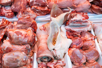 Closeup of fresh raw pork meat, bacon, ears and lard offered for sale in showcase. Large assortment...