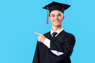 Male graduate student pointing at something on blue background