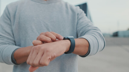 Athlete, guy in sportswear, unrecognizable young man looking at smart watch