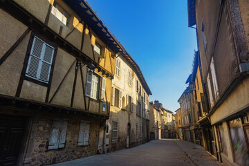 Fototapeta na wymiar Narrow street of Aurillac, southern France. Rows of old-fashioned houses along paved walkway.