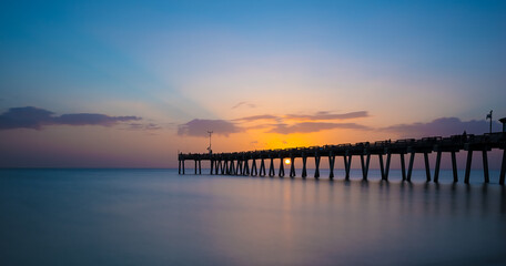 Fototapeta na wymiar Sunset over the Gulf of Mexico at the Venice Fishing Pier in Venice Florida USA