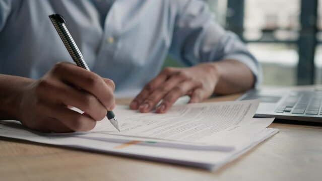 Close up unrecognizable man businessman writing paperwork report on desktop male hands signing business documents on office table student write educational test english exam studying in university 