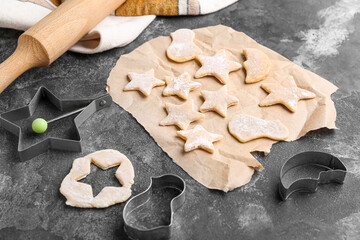 Composition with raw cookies and cutters on grunge background