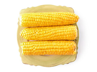 Plate with boiled corn cobs on white background