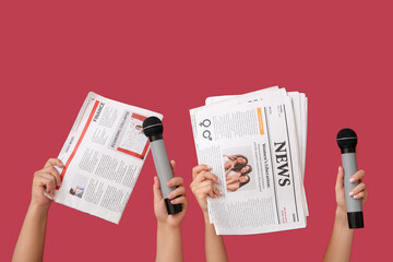 Female hands with newspapers and microphones on color background
