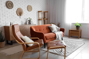 Comfortable armchair, ottoman and sofa in living room