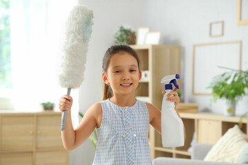 Cute little girl with pp-duster and detergent at home