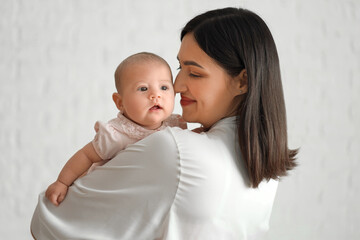 Young woman with her baby in bedroom, closeup