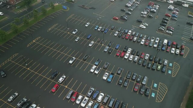 Aerial view of car parking of business center, mall, supermarket or hospital with cars in foggy day.