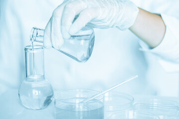 Scientific scene: Assistant engages in manipulations in the laboratory setting. Lab coat attire....