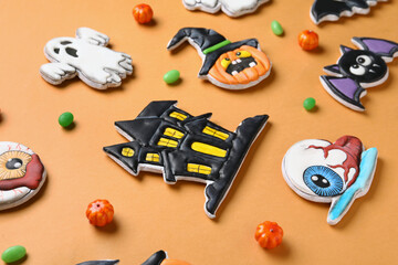 Composition with different tasty cookies and candies for Halloween celebration on beige background, closeup