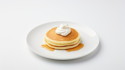 Image of a pancakes with a dollop of whipped cream on a white plate against a white background.