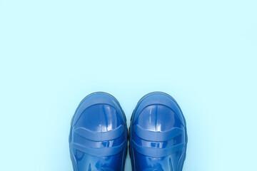 Blue gumboots on color background