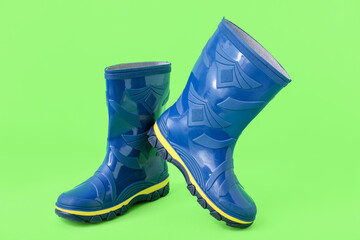 Blue gumboots on green background