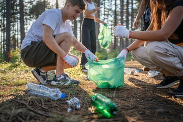 teenage friends young men women pick up waste garbage to clean forest
