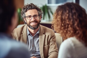 Portrait of smiling businessman talking to female colleague during meeting in office