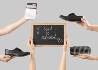 Female hands holding stationery, school shoes and blackboard with text BACK TO SCHOOL on grey...
