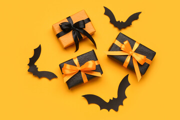Fototapeta premium Paper bats for Halloween party and gift boxes on orange background