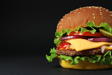 Delicious burger with beef patty and lettuce on dark background, space for text
