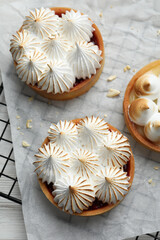 Tartlets with meringue on white wooden table, top view. Delicious dessert