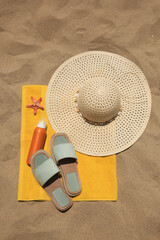 Fototapeta na wymiar Sunscreen, starfish and beach accessories on sand, top view. Sun protection care
