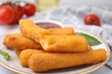 Tasty fried mozzarella sticks on white table, closeup