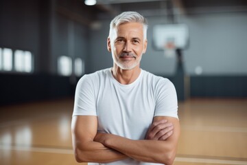 Portrait of confident senior man standing with arms crossed in basketball court - Powered by Adobe