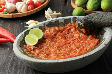 Sambal Tomat or Spicy Tomato paste on Stone Mortar and Pestle